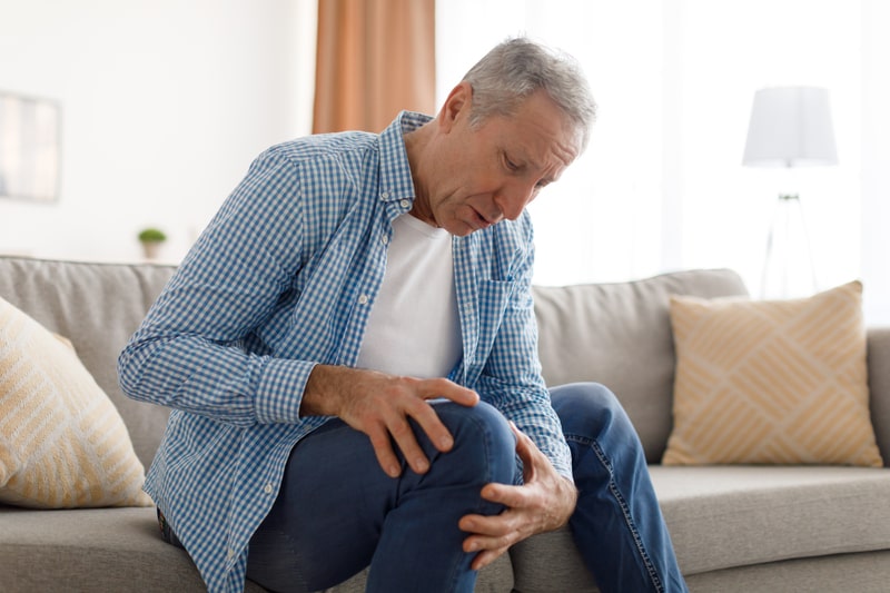 artrite reumatoide idoso sentado sentindo dor
