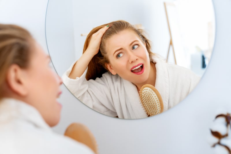 inflamacao no couro cabeludo mulher se olhando no espelho