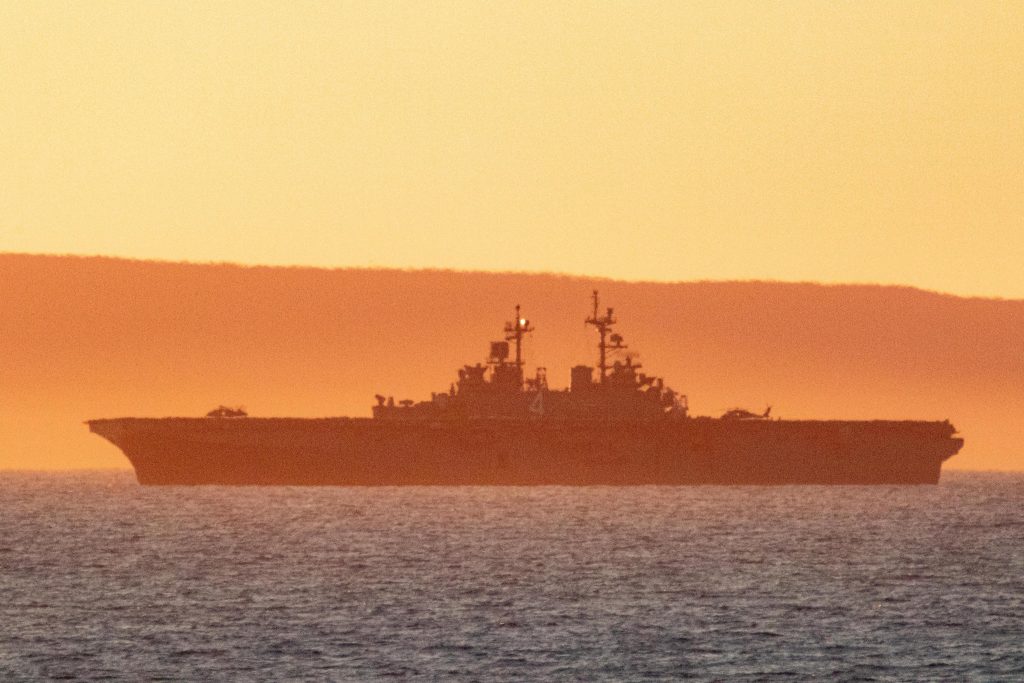 Pôr-do-sol com silhueta de um navio da Marinha dos EUA 