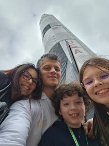 Mãe, pai, Lorenzo e a irmã dele posam para foto em frente a foguete nos EUA