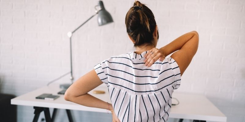 dor na coluna cbd mulher com a mao na coluna