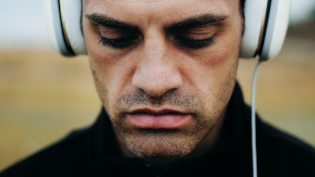 Homem concentrado ouvindo música em fones