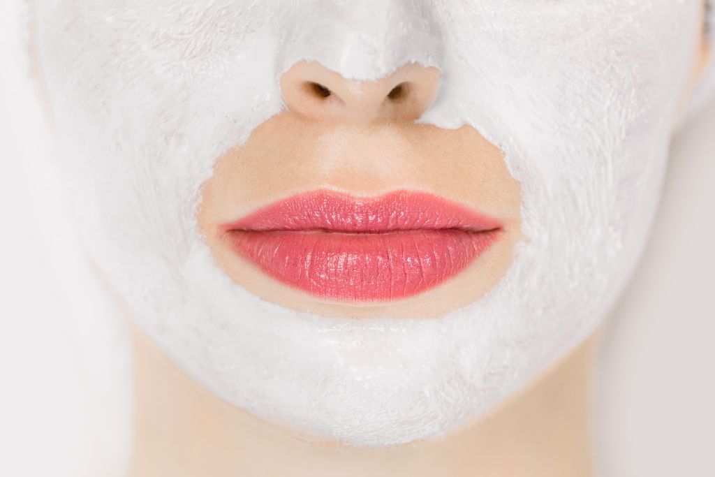 Imagem com boca de mulher usando máscara facial