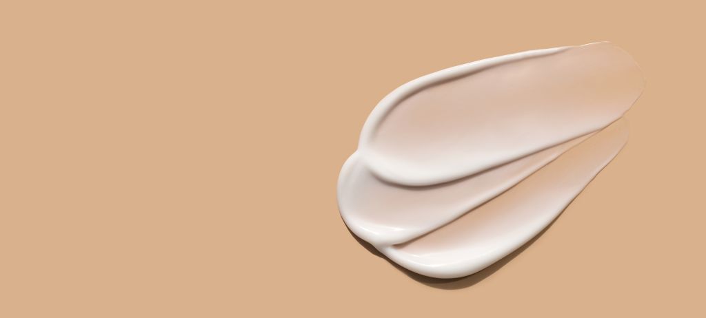 Creme branco espalhado sobre superfície bege