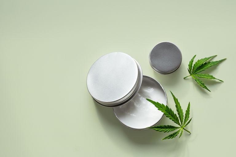 Pomada e folhas de cânhamo sobre uma mesa