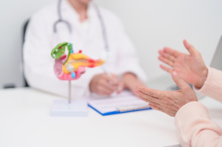 Paciente idosa conversa com médica em consultório