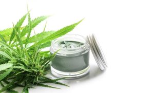 Frasco com pomada ao lado de planta
